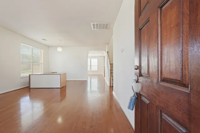 a view of a hallway with wooden floor and staircase