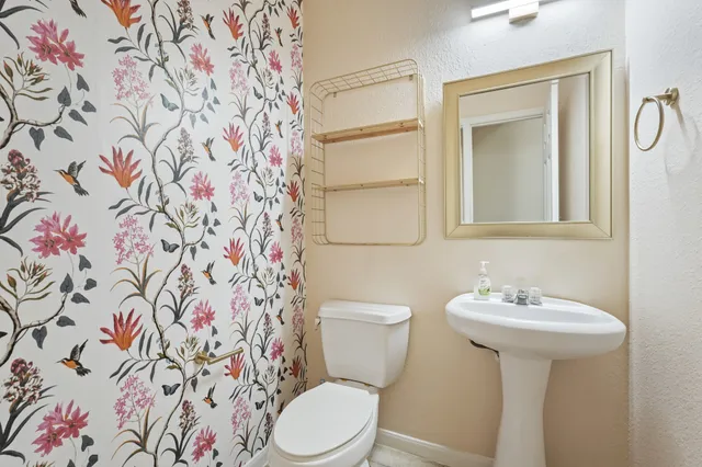 a bathroom with a toilet sink and mirror