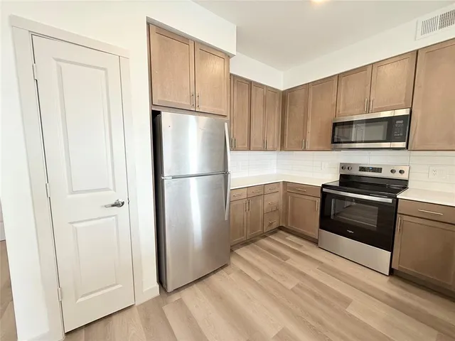 a kitchen with a refrigerator stove and microwave