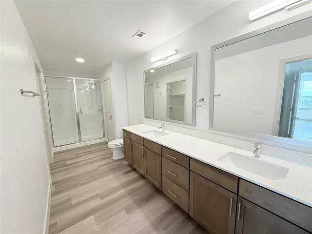 a bathroom with double vanity sinks and a shower