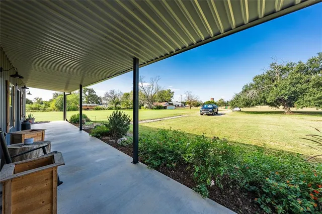 a view of a patio with table and chairs under an umbrella