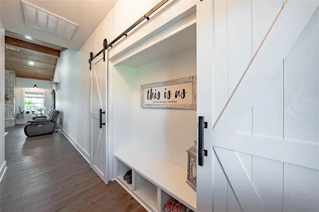 a view of a hallway with wooden floor and staircase