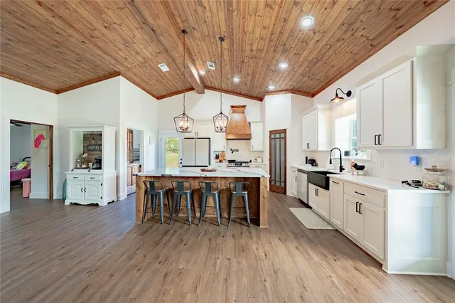 a large kitchen with lots of counter space and furniture wooden floor