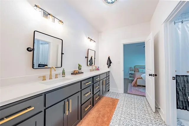 a en suite bathroom with a double vanity sink and a mirror