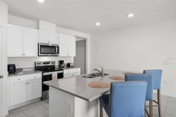 a kitchen with a sink white cabinets and stainless steel appliances