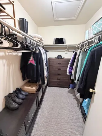 a view of walk in closet with clothes and shoes