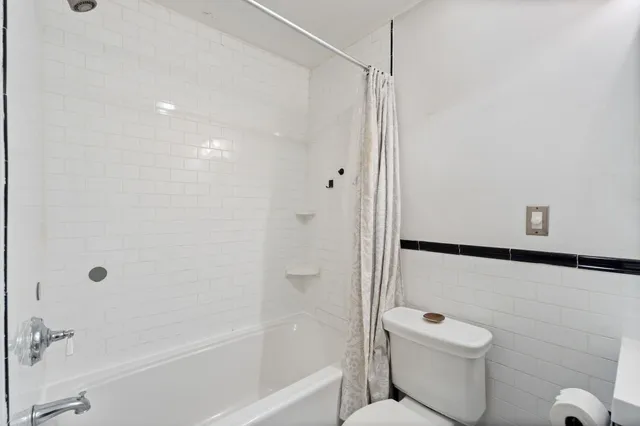 a bathroom with a shower a toilet and a shower