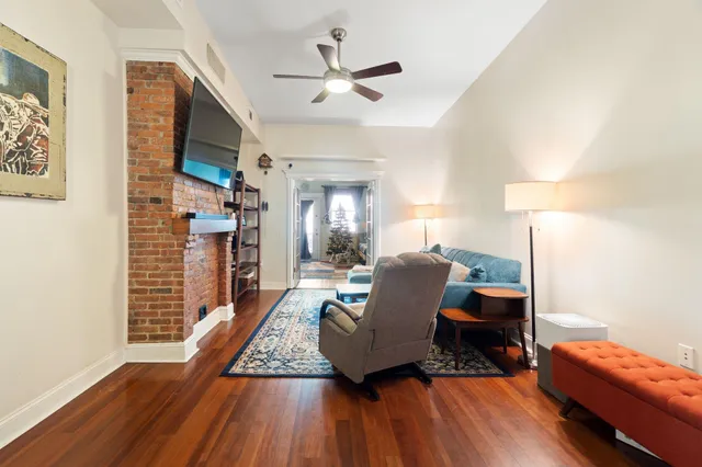 a living room with furniture and a wooden floor
