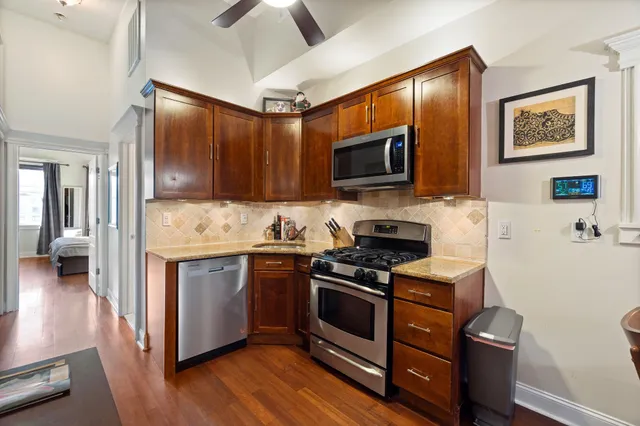 a kitchen with stainless steel appliances a stove microwave and sink