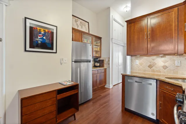 a kitchen with stainless steel appliances granite countertop a refrigerator and a stove top oven