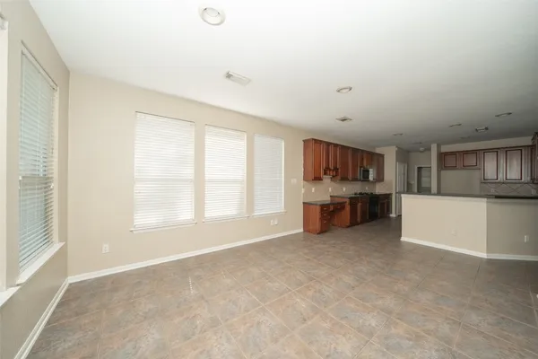 a view of kitchen with refrigerator and windows