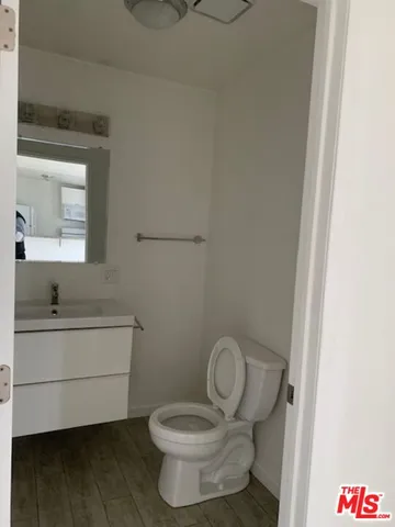 an empty room with wooden floor and cabinet