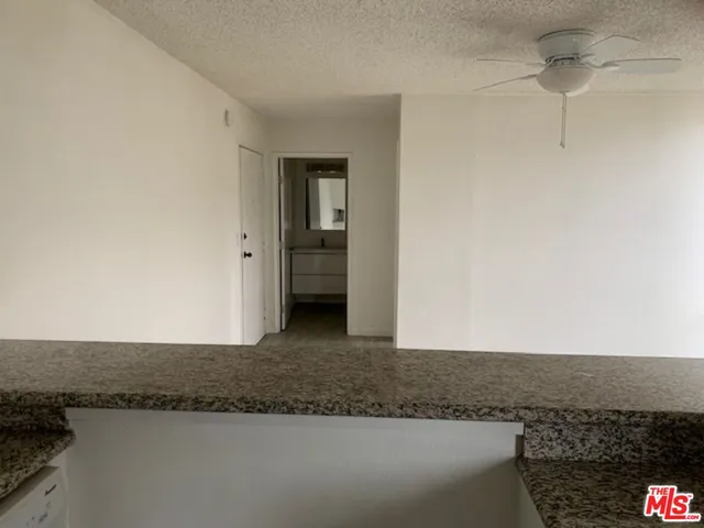 a bathroom with a granite countertop sink a toilet and mirror