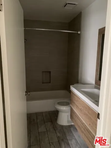 an empty room with wooden floor & windows