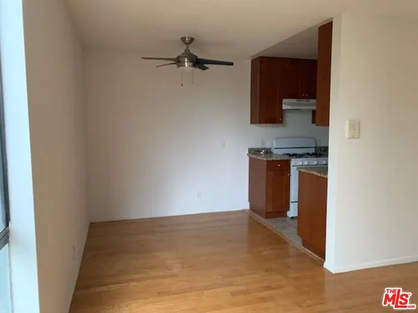 a view of a kitchen with fridge and wooden floor