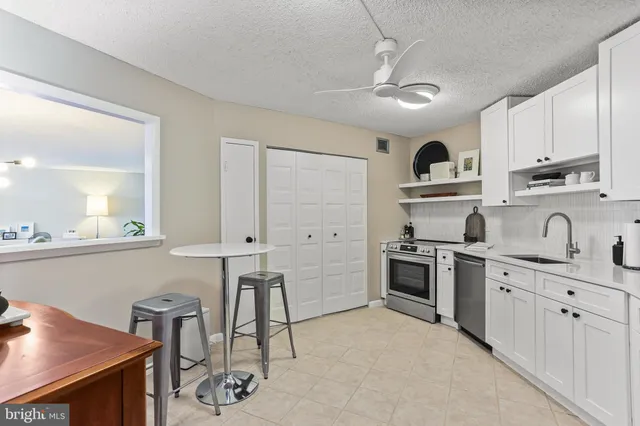 a kitchen with stainless steel appliances a refrigerator sink and cabinets