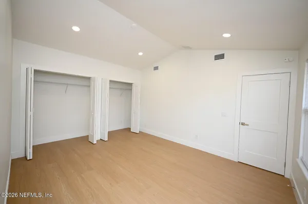 a spacious bathroom with a tub shower and mirror