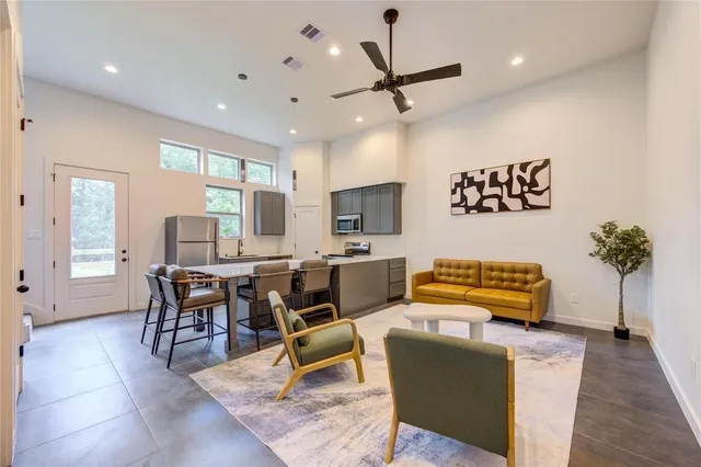 a living room with furniture a chandelier and a flat screen tv