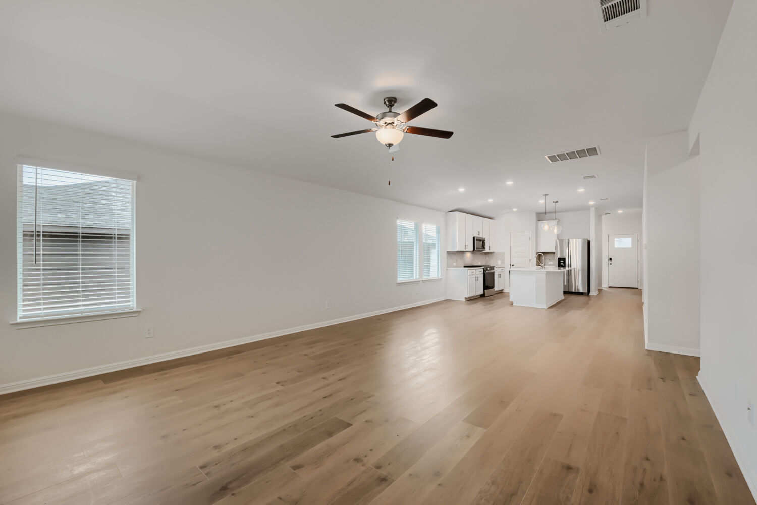 146 Diablo Rim Terrace Dripping Springs, TX 78620 - Photo 11 of 32 A well-lit open-concept space connects the living area with a contemporary kitchen.