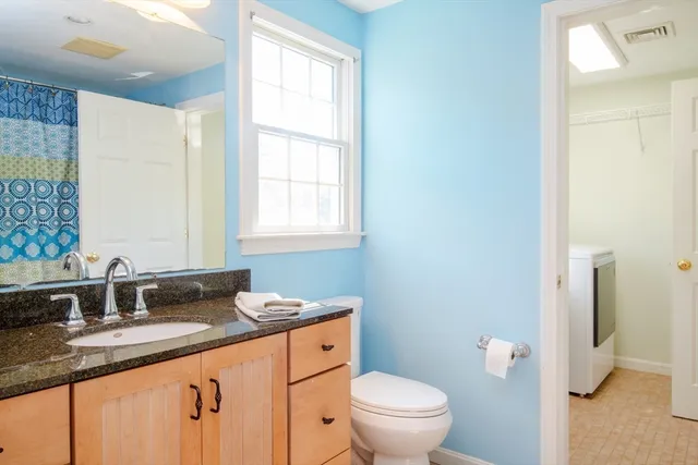 a bathroom with a granite countertop sink toilet and a mirror