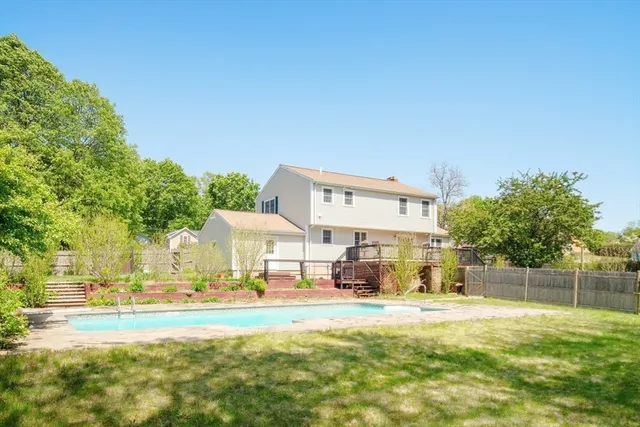 a view of a house with a big yard and large trees