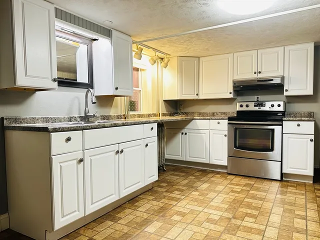 a kitchen with stainless steel appliances granite countertop a sink a stove and cabinets