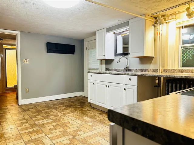 a kitchen with granite countertop a sink and cabinets