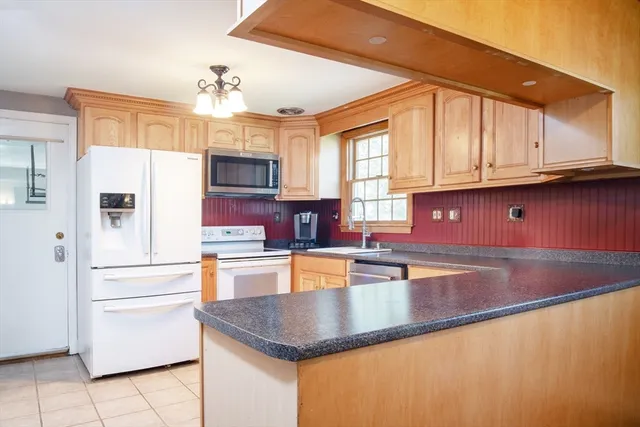 a kitchen with stainless steel appliances granite countertop a sink refrigerator and cabinets