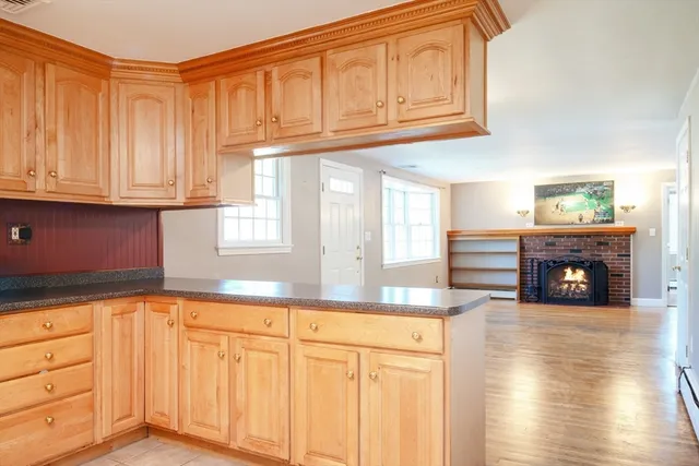 a kitchen with granite countertop a sink cabinets and a wooden floor