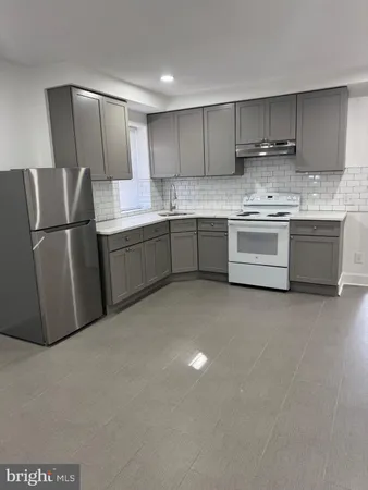a kitchen with a refrigerator sink and cabinets
