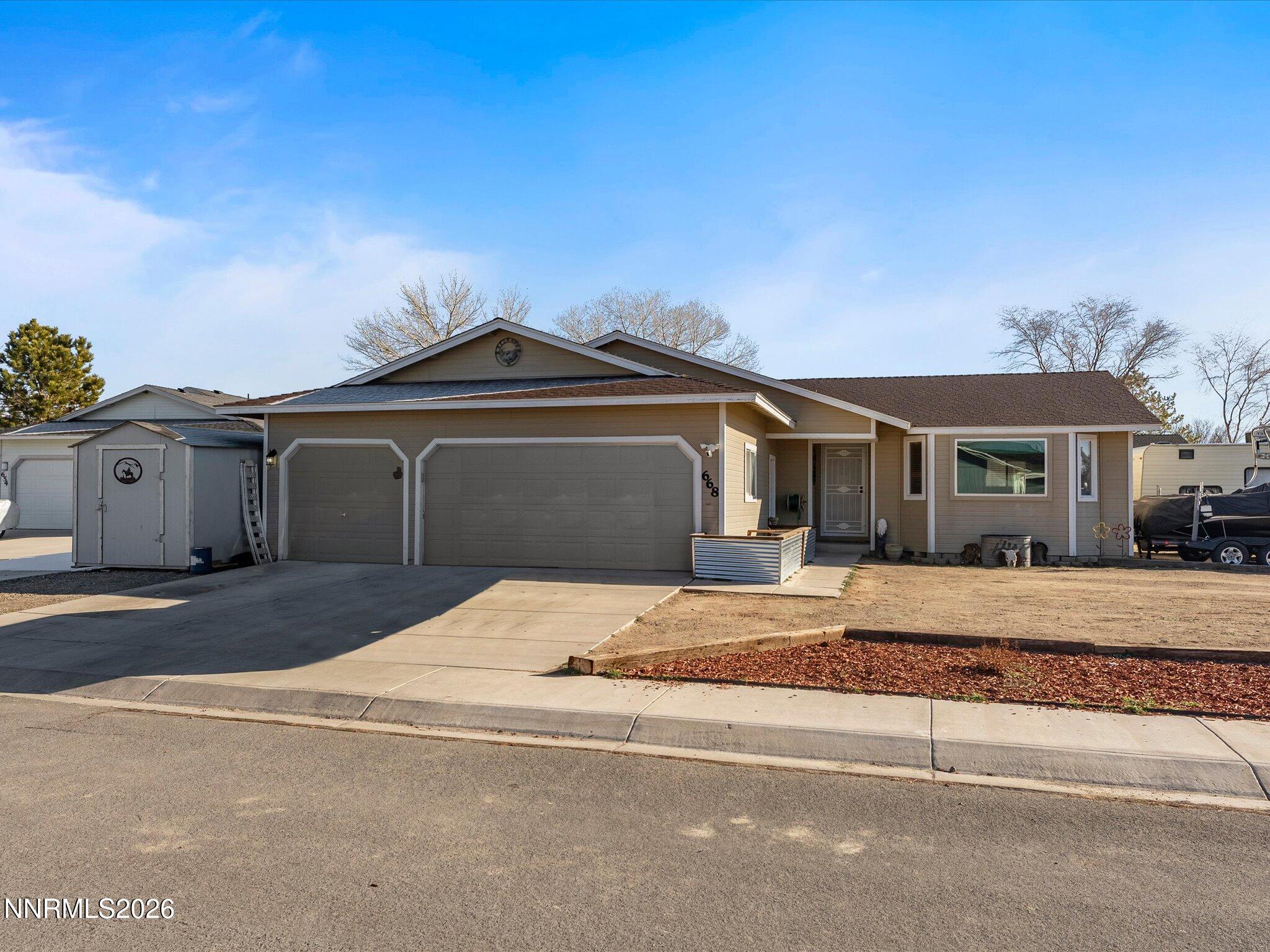 668 Farm Circle Fernley, NV 89408 - Photo 1 of 46 a front view of a house with a garden
