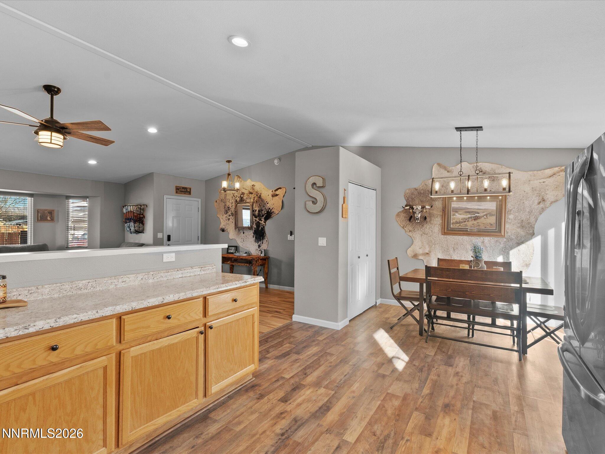 668 Farm Circle Fernley, NV 89408 - Photo 17 of 46 a kitchen with stainless steel appliances granite countertop a stove a sink dishwasher and a dining table with wooden floor