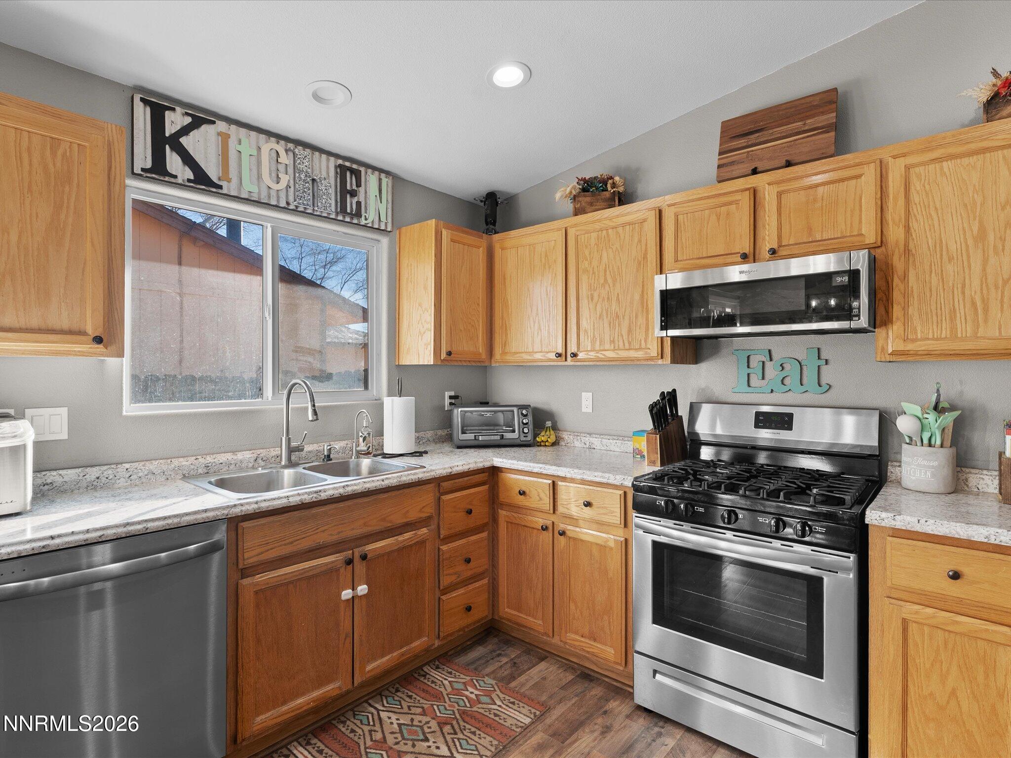 668 Farm Circle Fernley, NV 89408 - Photo 18 of 46 a kitchen with stainless steel appliances granite countertop a sink a stove and cabinets