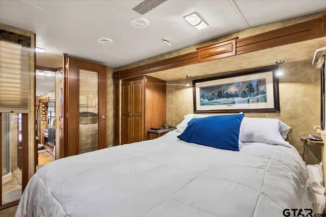 a bedroom with a large bed and a large mirror