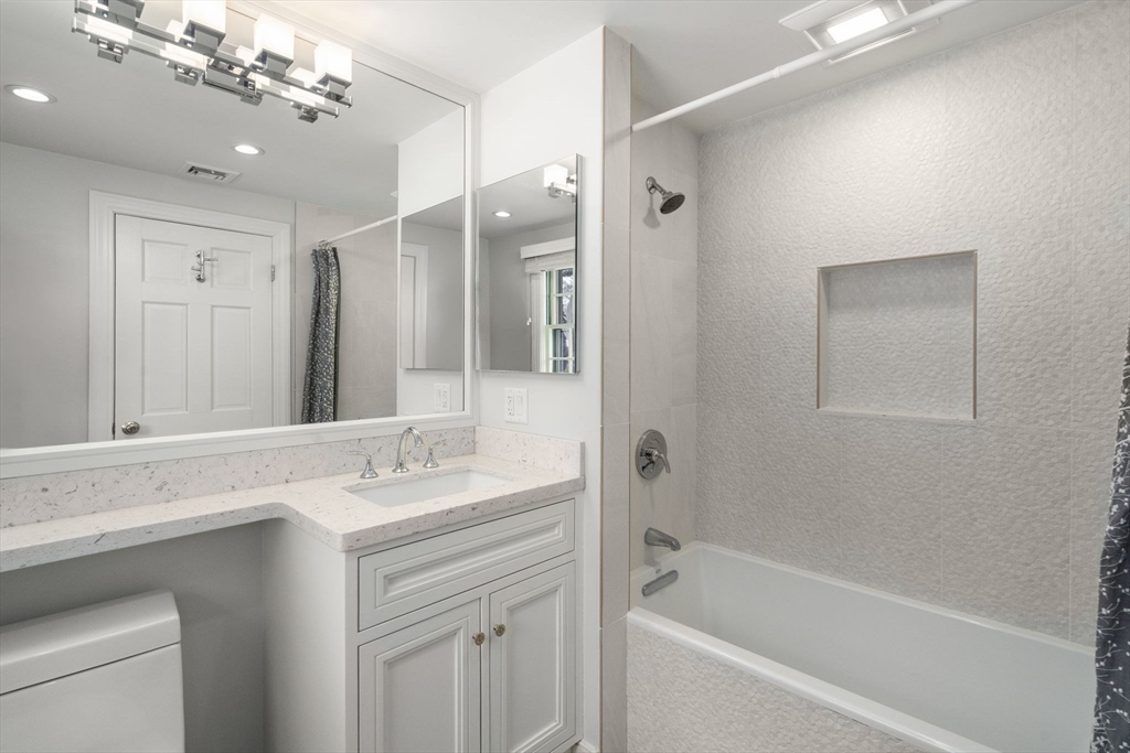 20 Windsor Road Needham, MA 02492 - Photo 22 of 29 a bathroom with a bathtub shower sink vanity and mirror