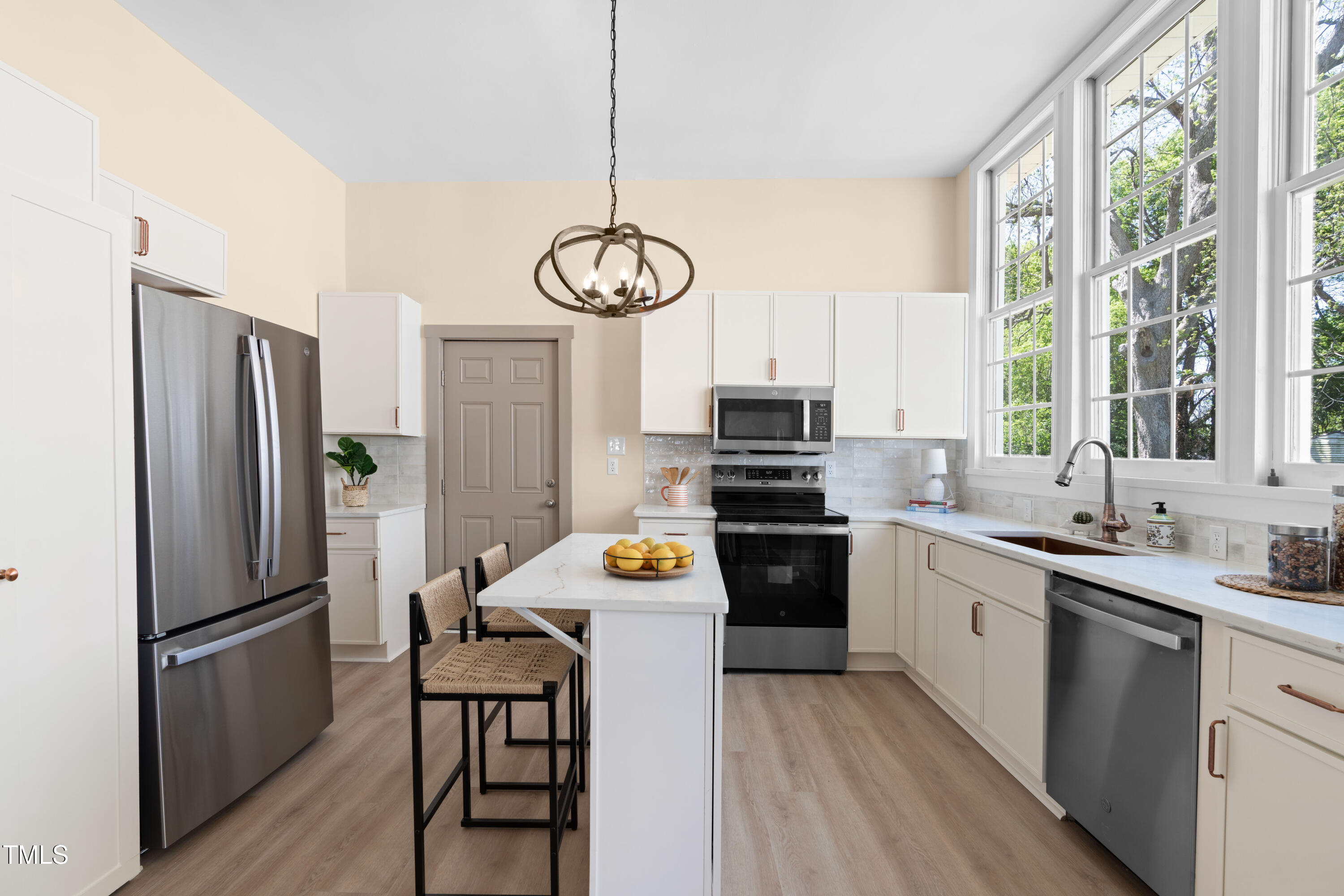 314 Bledsoe Avenue Raleigh, NC 27601 - Photo 9 of 21 a kitchen with stainless steel appliances a refrigerator a stove a sink cabinets and a dining table