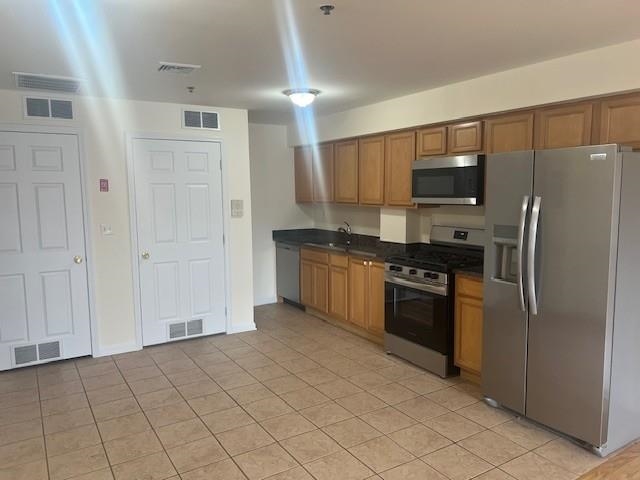 a kitchen with stainless steel appliances granite countertop a refrigerator and a stove top oven