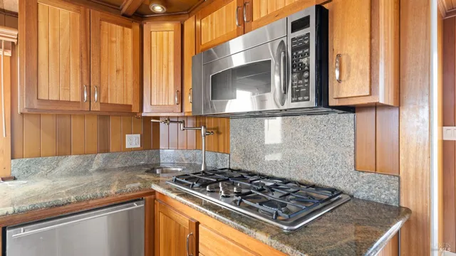 a kitchen with granite countertop a sink and a stove