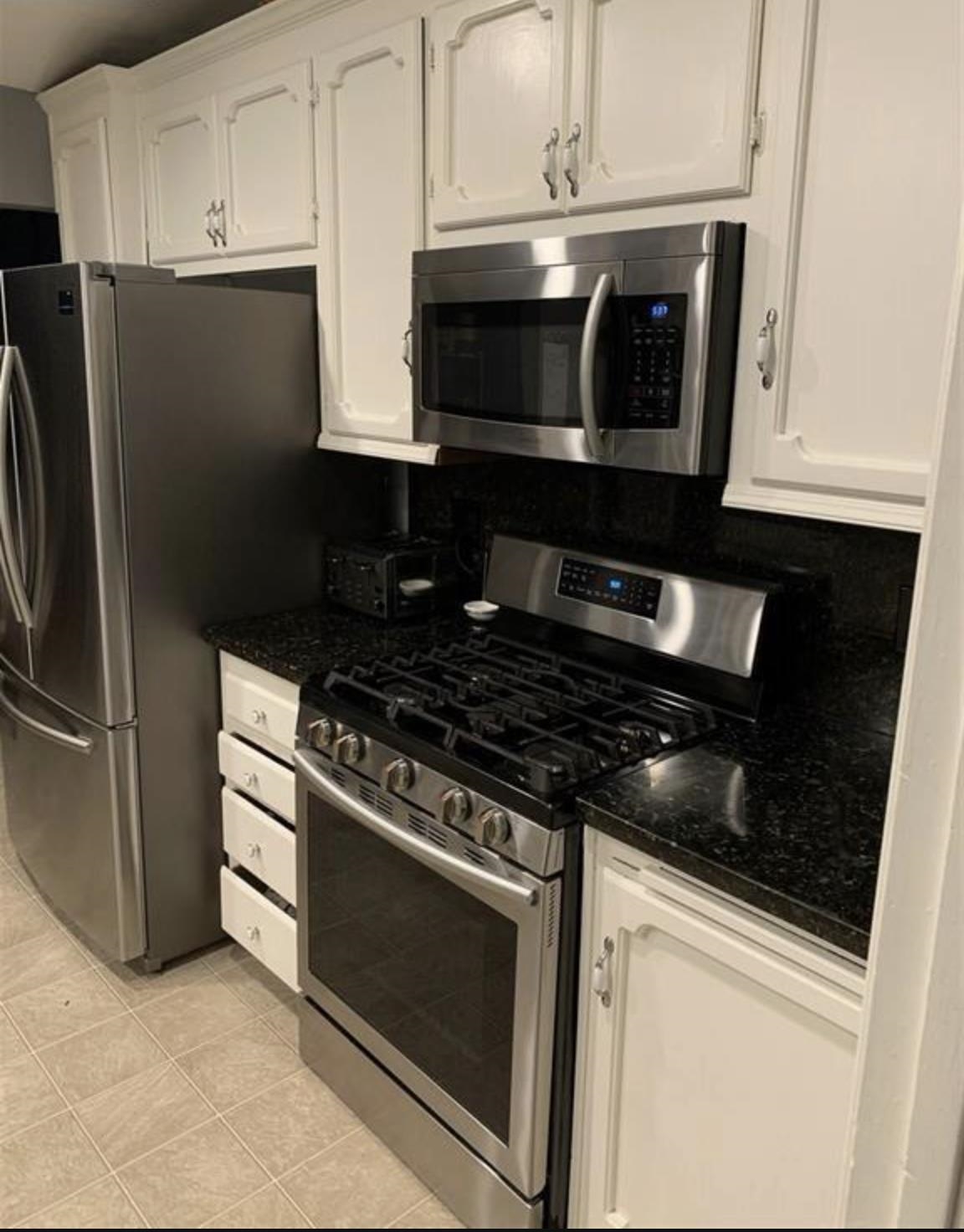 5250 Riverlake Road Discovery Bay, CA 94505 - Photo 4 of 18 Kitchen with appliances with stainless steel finishes, white cabinetry, and dark stone countertops