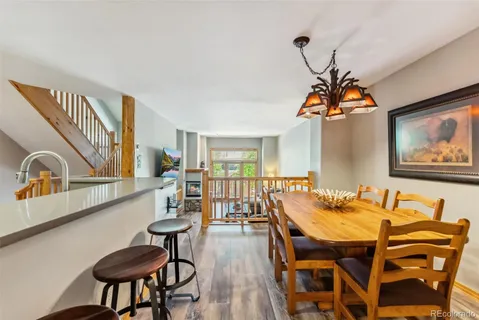 a dining room with furniture a chandelier and wooden floor