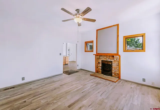 a view of empty room with a fireplace and wooden floor