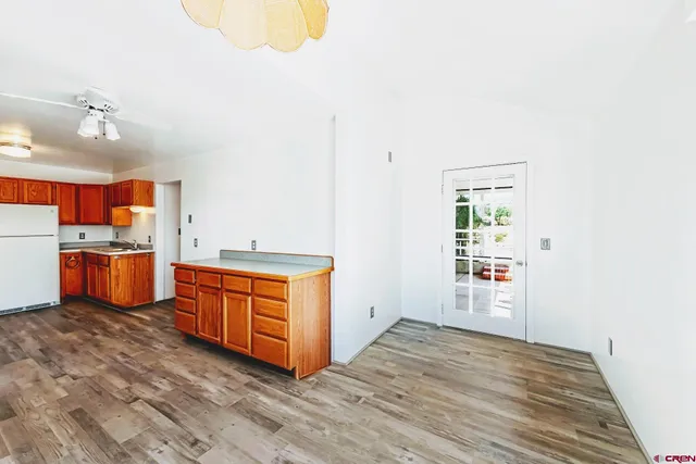 a kitchen with stainless steel appliances granite countertop a stove a sink and a refrigerator with wooden floors