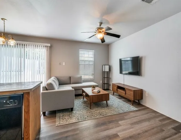 a living room with furniture a flat screen tv and a window