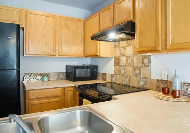 a kitchen with stainless steel appliances a sink a stove and a refrigerator