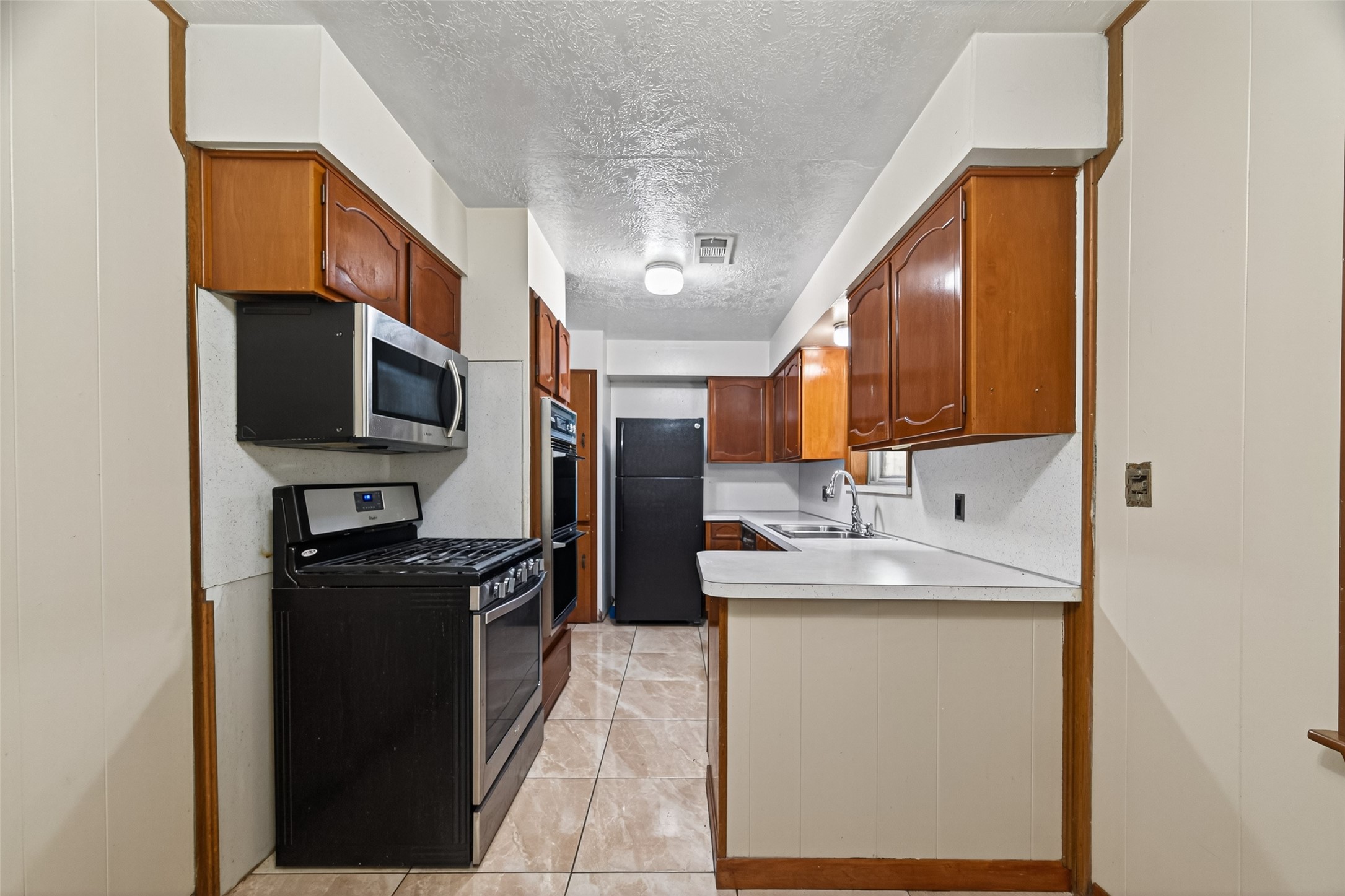 2609 Raspberry Lane Pasadena, TX 77502 - Photo 15 of 40 a kitchen with stainless steel appliances granite countertop a sink stove and refrigerator