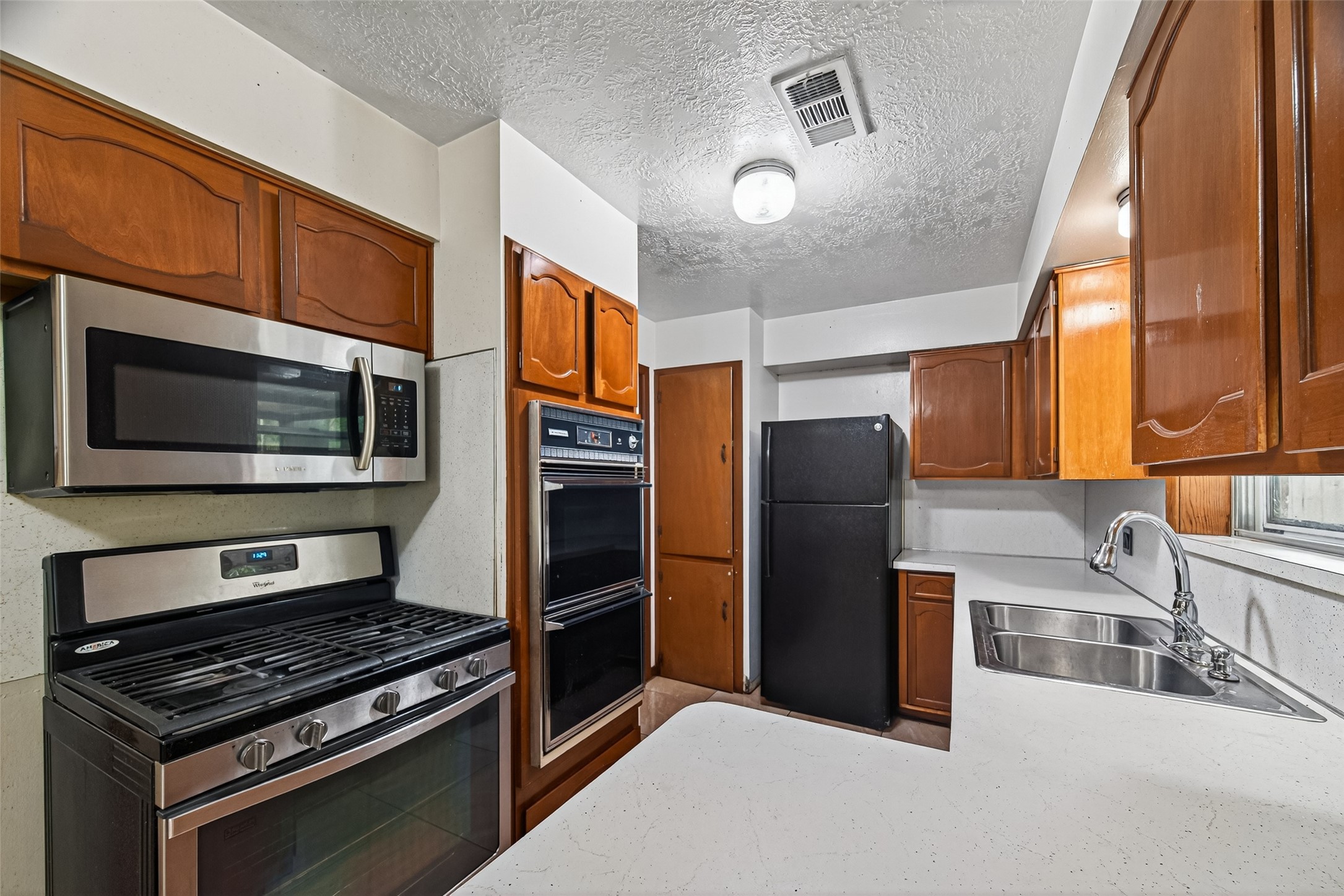 2609 Raspberry Lane Pasadena, TX 77502 - Photo 18 of 40 a kitchen with stainless steel appliances granite countertop a refrigerator and a stove