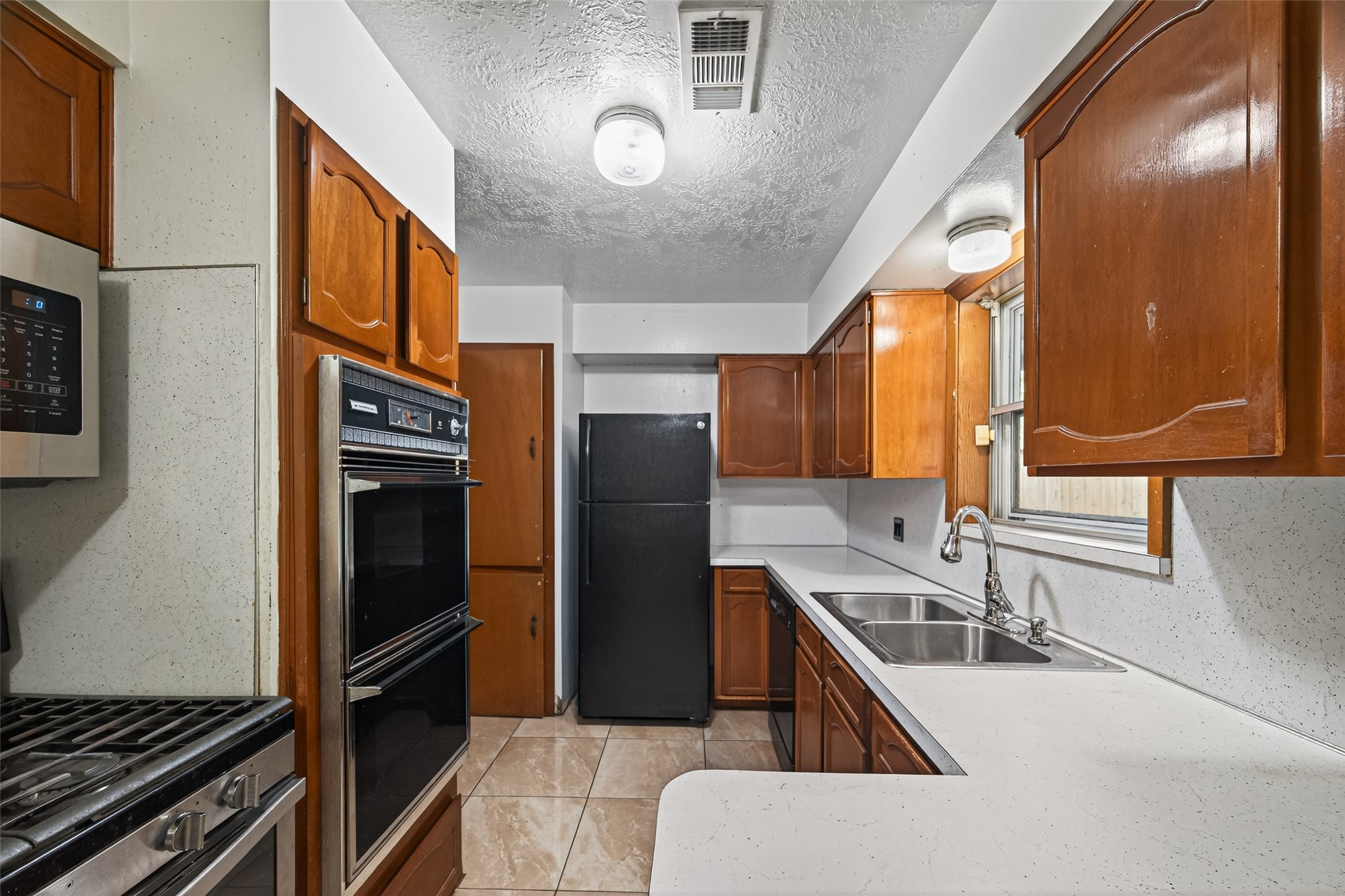 2609 Raspberry Lane Pasadena, TX 77502 - Photo 19 of 40 a kitchen with stainless steel appliances granite countertop a sink stove and refrigerator