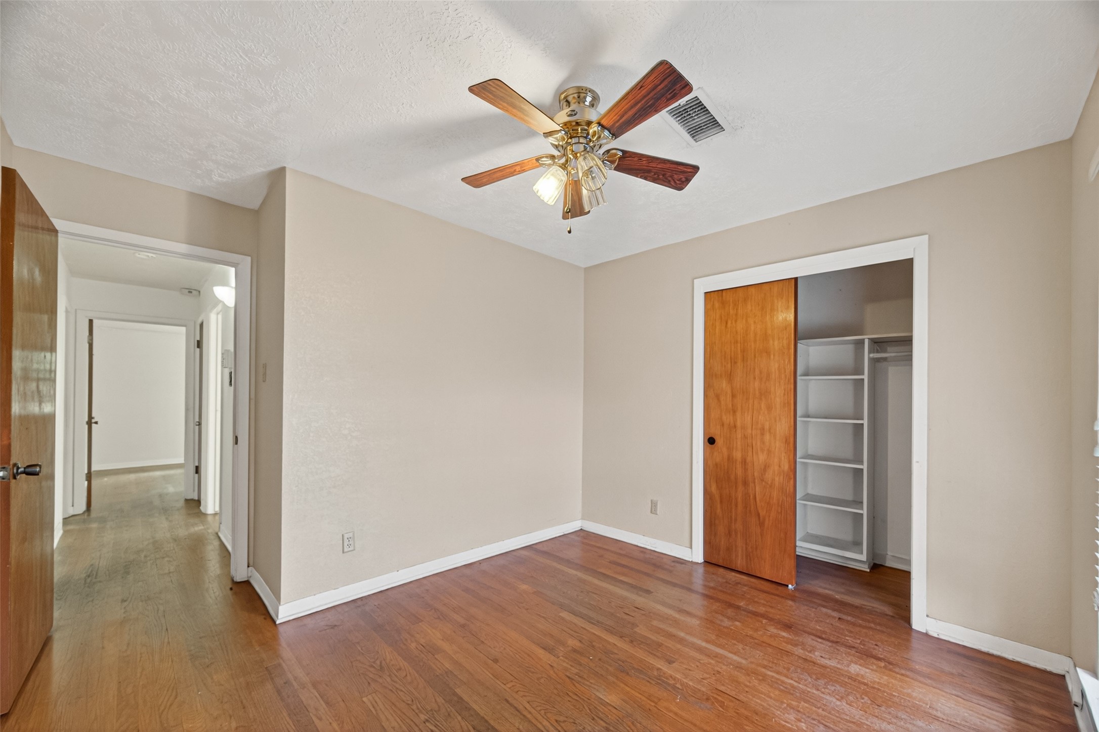 2609 Raspberry Lane Pasadena, TX 77502 - Photo 22 of 40 a view of an empty room with wooden floor and a ceiling fan