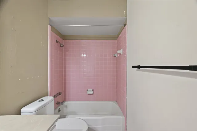 a bathroom with a bathtub shower sink and toilet
