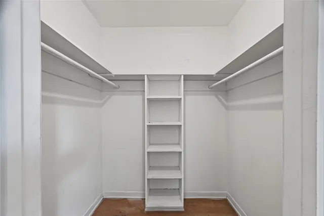 a view of walk in closet with empty racks